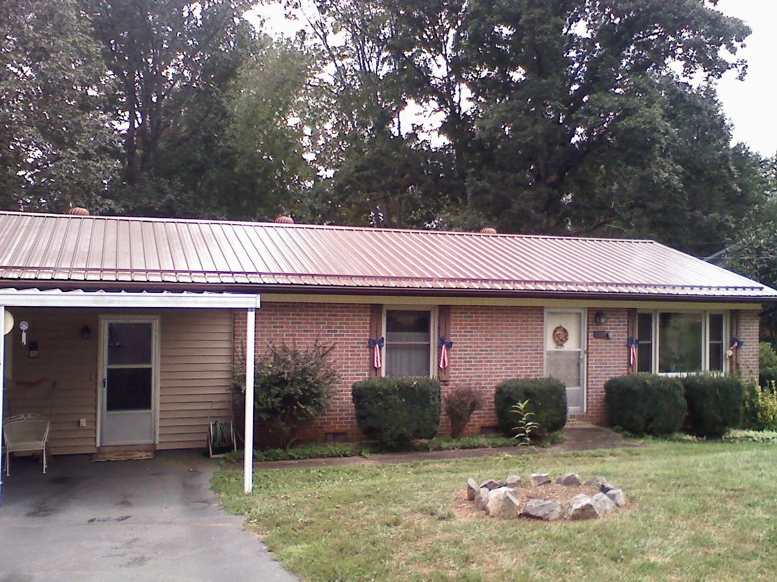 Bronze metal roof and carport on a brick ranch home — Roof Repair work by our crew in Walterboro